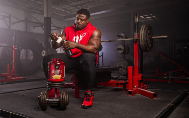 man holding bsn shaker while sitting on steps